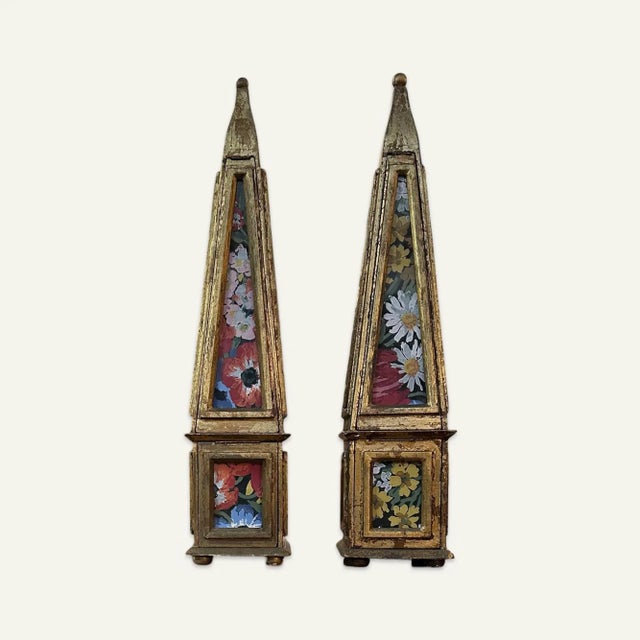 Pair of gilded wood and glass paneled tabletop obelisks. These obelisks feature floral paper pinned behind the glass...