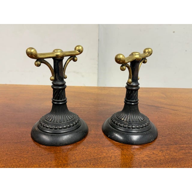 Design Plus Gallery presents a Pair of Fire Dogs of Antique Age. They are heavy and made from cast iron with brass tops....