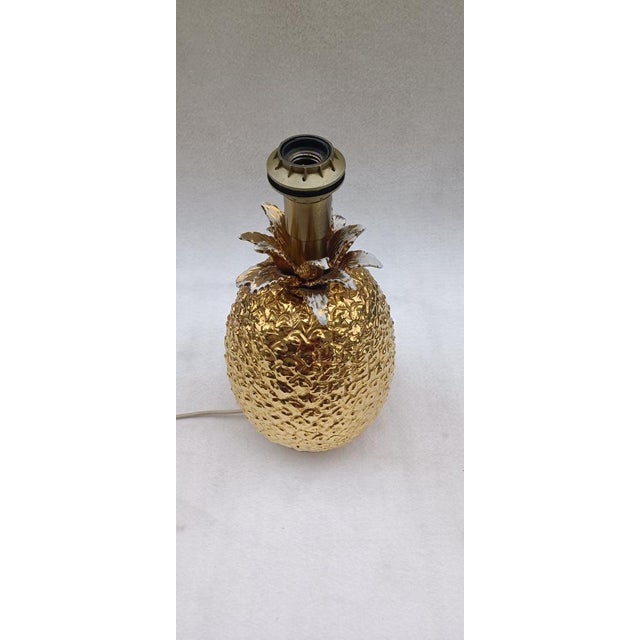 Pineapple-shaped table lamp in golden ceramic and metal base. Italian manufacturing from the 70s. It has some worn parts...
