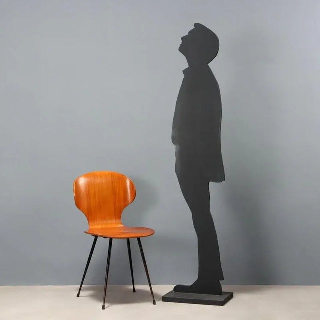 Vintage dining chair with curved plywood seat, black enameled metal legs. This piece is attributed to the mentioned...