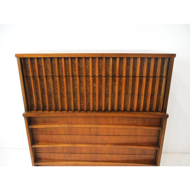 A walnut five drawer mid -century highboy dresser chest with unique curved front and streamline full length pulls having...