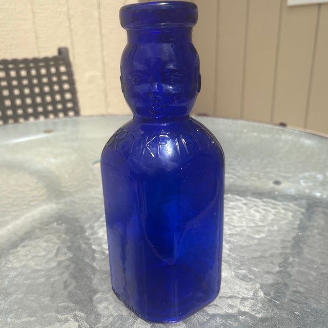 The Brookfield "Baby Top" (or "Baby Face") bottle is a vintage-style, one-quart decorative glass bottle featuring a...