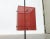 Minimalist mid century shield stand made of perforated sheet in red and black. Cubic shapes and clear lines go through...