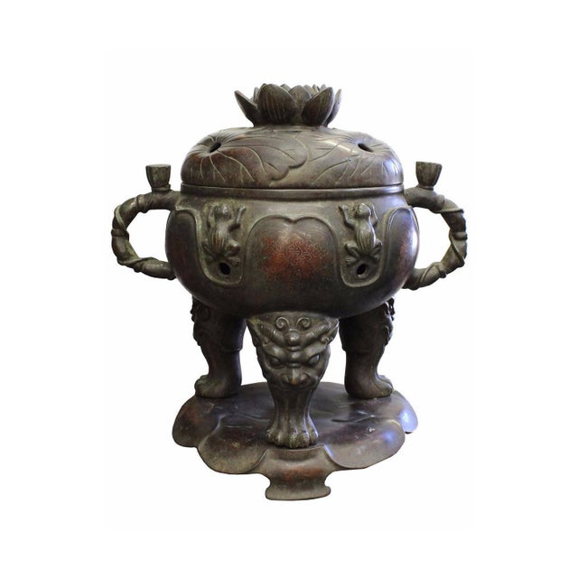 This ornate bronze incense burner, or censer, stands as a striking example of traditional East Asian metalwork,...