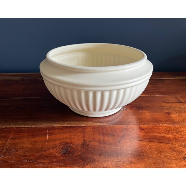 Simple neoclassic design with a footed base and fluted body. Matte cream finish on a round form. Nice size for a...