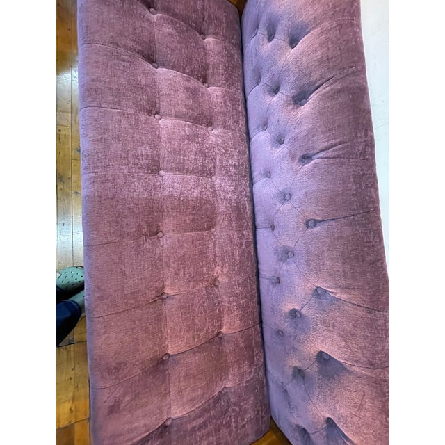 Plush button-tufted upholstery paired with sculpted walnut arms and tapered legs creates a sleek, low-profile silhouette....