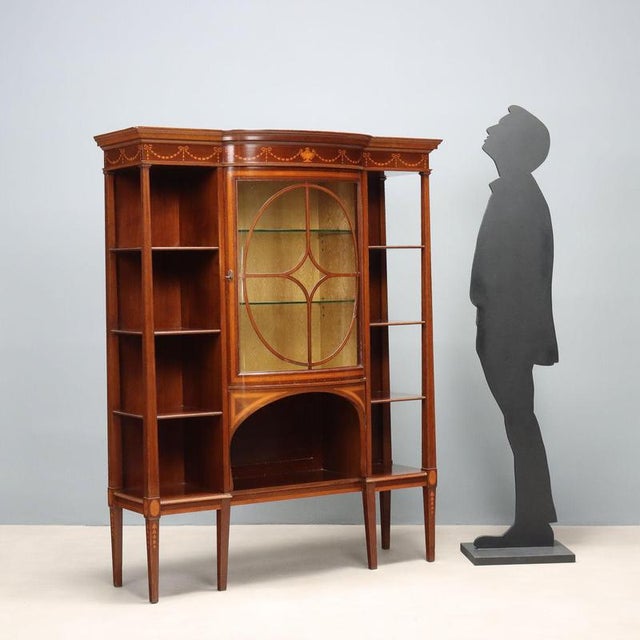Late 19th-century English display cabinet made of mahogany with elegant stringing and maple inlays. The protruding central...