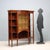 Late 19th-century English display cabinet made of mahogany with elegant stringing and maple inlays. The protruding central...