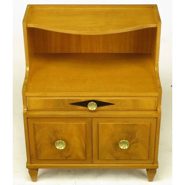 Grosfeld House nightstand in bleached mahogany and figured walnut. Single drawer with two cabinet doors that open to...