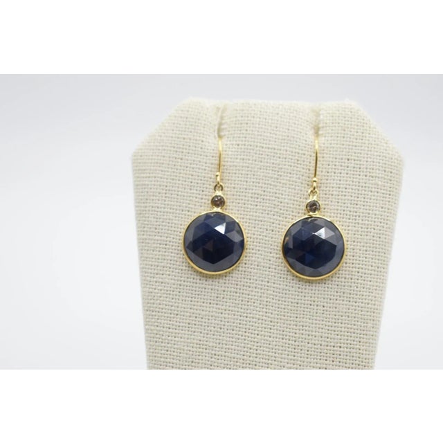 This is a beautiful pair of diamond and sapphire earrings set in 18k yellow gold. There are round brilliant cut diamonds...