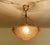 French Art Deco Pendant Light featuring a pink glass shade with geometric pattern and stylised floral ornaments mounted on...
