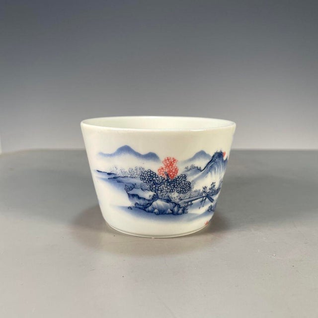 This is a charming vintage porcelain teacup, decorated in the classic blue and whitepalette with accents of underglaze...