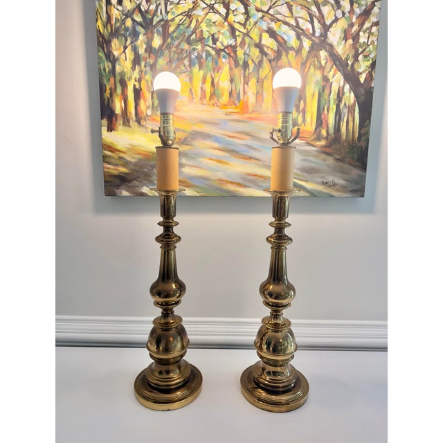 Striking pair of tall vintage brass table lamps featuring an elegant, architectural baluster form with beautifully...
