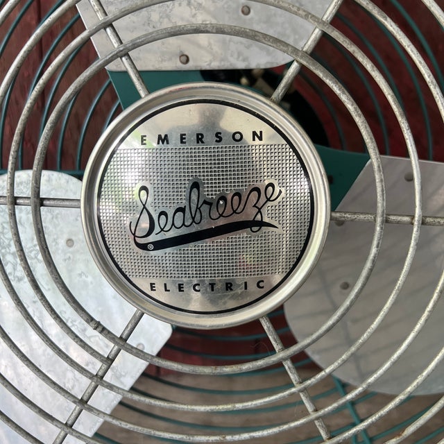 This vintage Emerson Seabreeze electric fan features a striking turquoise metal frame and three aluminum blades. With its...