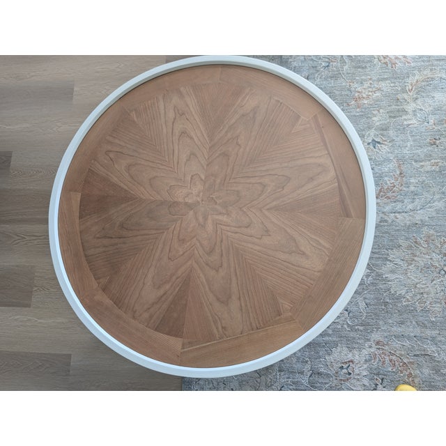 Beautifully refurbished two-tone round coffee table with natural wood accents on the top and sides leading to white...
