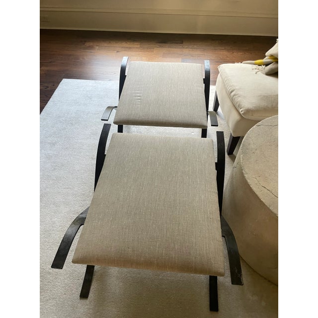 Handmade X-base ottomans featuring sculptural, hand-forged iron frames with elegant curved lines. The iron is finished in...