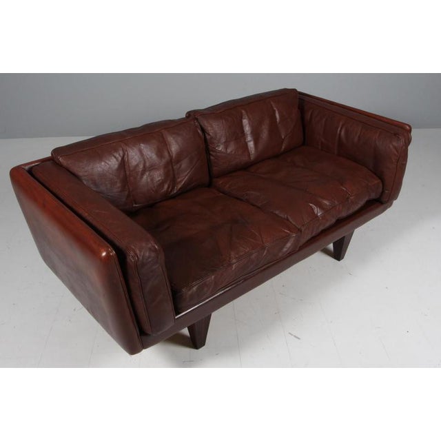 Illum Wikkelsø 1919-1999. two-seat sofa, freestanding, upholstered in brown patinated leather, loose cushions with down...