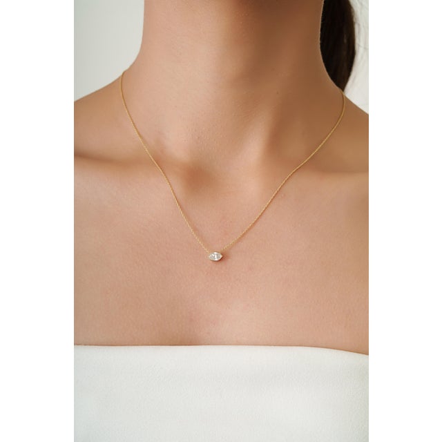 This elegant pendant necklace showcases a 0.63 carat marquise-cut diamond set in 14K yellow gold. The Diamond measuring...