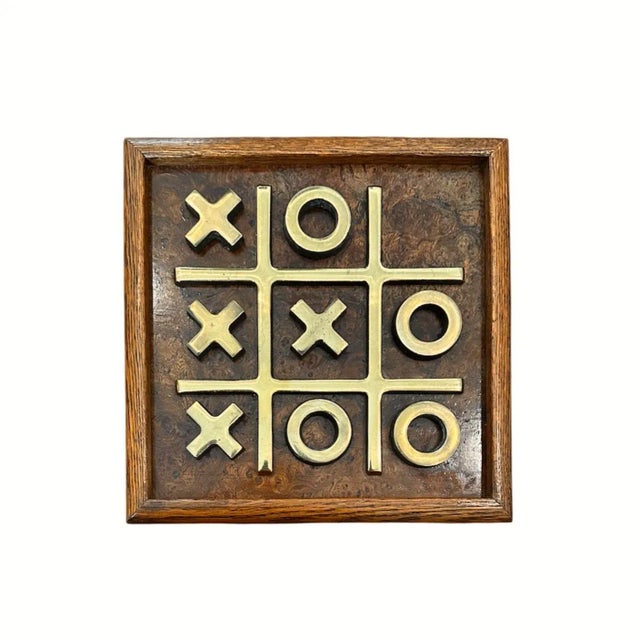 A vintage Tic-Tac-Toe set, finished with a burl wood inset with warm, golden-hued brass toned accents. This set features a...