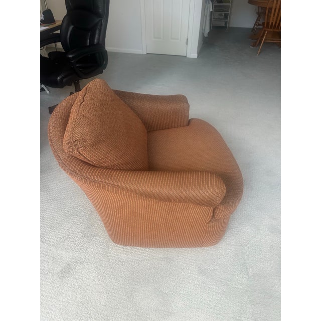 Vintage sculptural lounge chair featuring a distinctive rounded silhouette and richly textured brown ribbed upholstery....