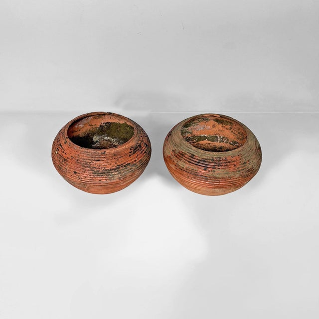 Italian rustic terracotta vases, 1930s Pair of terracotta vases with an ovoid body and wide opening. They feature a low,...