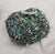 A set of four bird nests in glittery shades of aqua, blue and green, each holding two soft sheen aqua eggs. Clips on the...