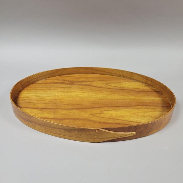 A set of two handcrafted Shaker-style oval serving trays by Ken Baker executed in warm American cherry and butternut woods...