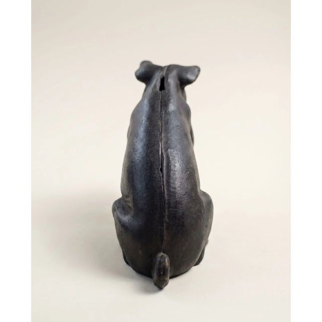 A charming vintage cast iron pig figure featuring a simple folk-art inspired design and substantial weight. Finished in a...