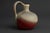 A mid-century jug vase by JOPEKO, West Germany, featuring a compact form and bold fat-lava glaze. The surface is a dynamic...