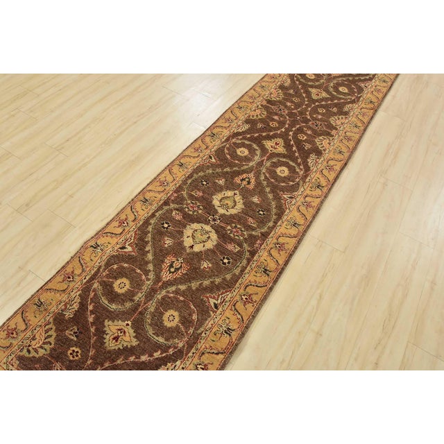 A traditional Agra runner hand-knotted with an all-wool pile on a cotton foundation. This finely woven oriental rug...