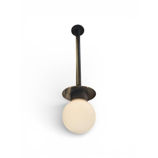 Brass and opal glass hanging ceiling light by Urban Electric Company in Antique Gilt finish. Pipe Hang model with a...