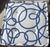 One large, plush white floor cushion with dark blue abstract swirls. The bottom side features brown swirls, rather than...