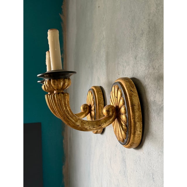 A pair of partial gilt and black hardwired sconces.
