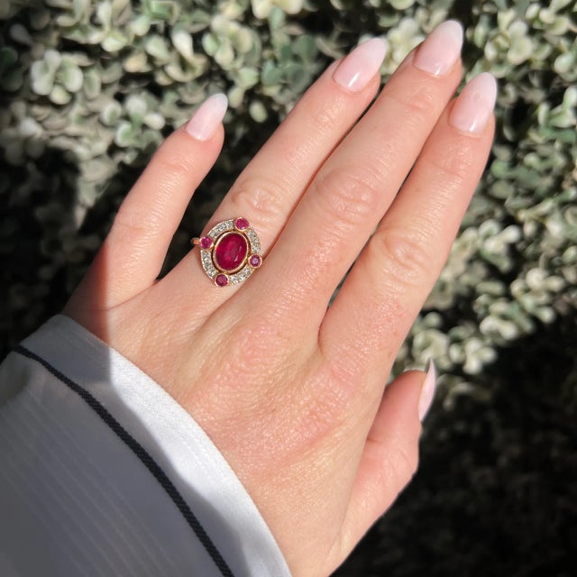 Vintage 1970s halo ring in 18k gold. It is set in its center with a natural Burmese ruby ​​of approximately 2.14 carats,...