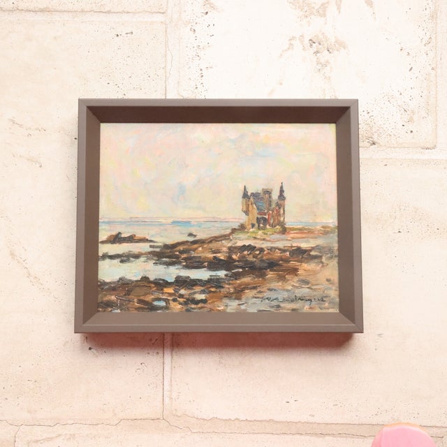 20th Century French Seaside Castle Painting depicts a charming coastal view with a small castle-like structure perched...