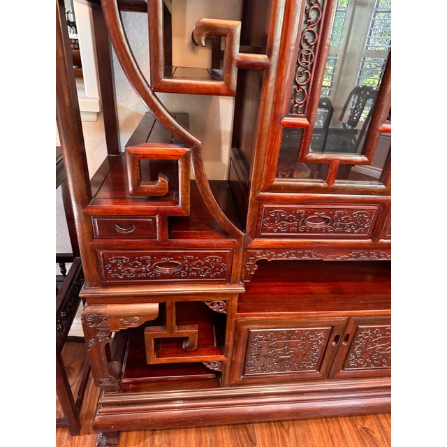 A showstopping centerpiece featuring staggered shelving, intricate cloud/scroll latticework, a glass-front accent cabinet,...