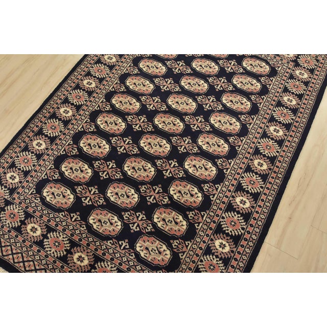 A tribal Bokhara rug hand-knotted with fine wool on a cotton foundation. This rug features rows of repeating medallions...