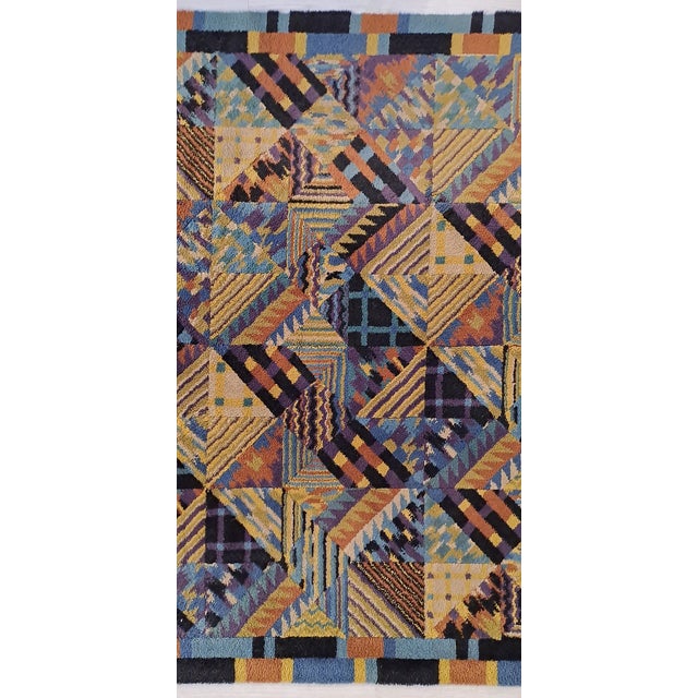 Wool rug with zigzag patterns in the signature colors of Ottavio Missoni. It bears the designer's signature on the pile....