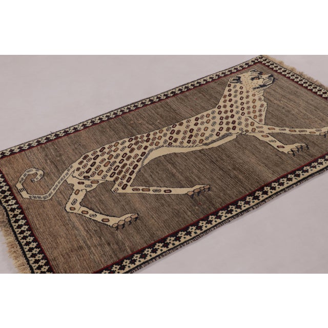 Hand-knotted in wool circa 1950-1960, this 3x6 vintage Persian Gabbeh runner rug is a captivating example of the “Lion...