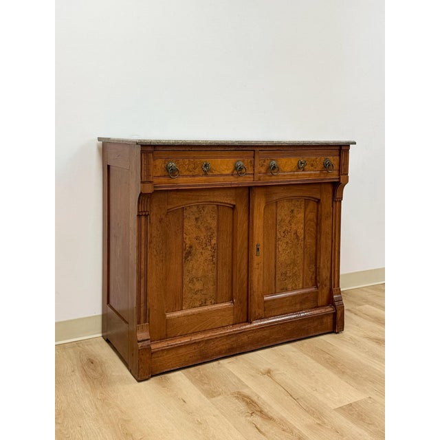 This antique French buffet showcases a genuine gray marble top set above rich burlwood door and drawer fronts, offering...