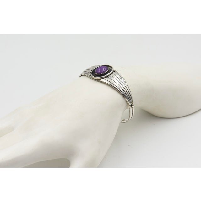 Vintage Native American sterling silver cuff bracelet featuring an oval sugilite set in a sawtooth bezel. Marked on the...