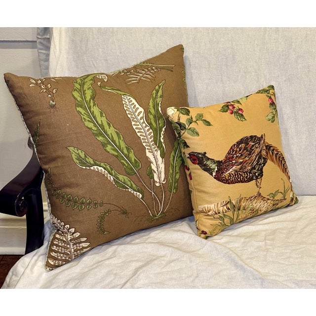 A distinctive pair of custom decorative pillows featuring richly patterned linen textiles with a collected, English...