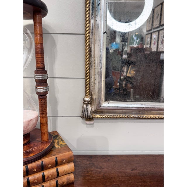 This exquisite Antique Louis Philippe Mirror, adorned with a rope motif frame and decorative crest. a gilded finish,...