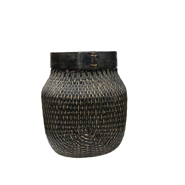 This striking hand-woven vessel marries traditional craftsmanship with a bold, contemporary aesthetic. Featuring a rich,...
