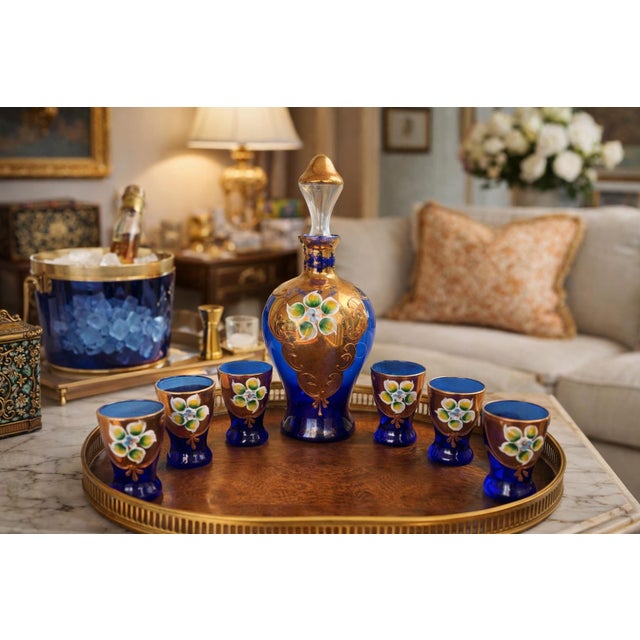 This decorative mid-century glass decanter set features richly saturated cobalt blue glass accented with hand-applied gilt...