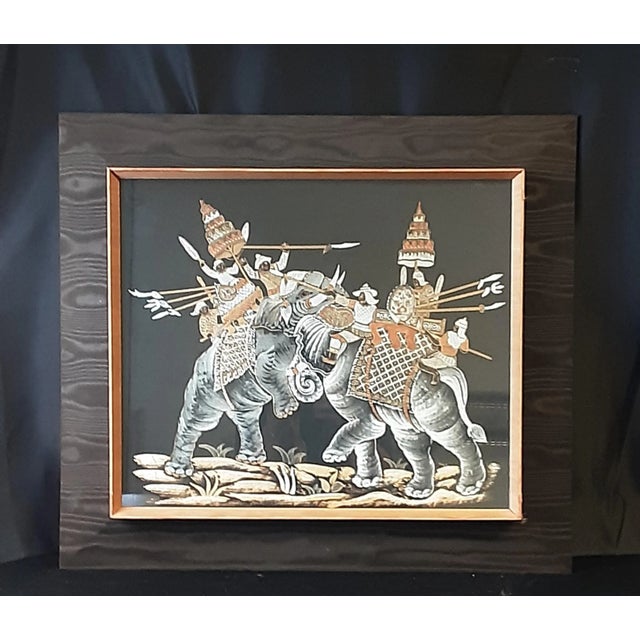 Vintage Thai silk painting of Indian Mughal battle scene with elephants. The frame is wood covered in brown and...