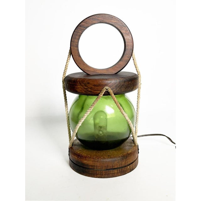 Wooden table lamp with green glass globe, France, 1960s. An elegant French table lamp from the 1960s combining a turned...