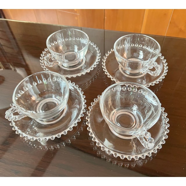 Set of four vintage blown glass "Candlewick" tea cups and saucers, manufactured by the Imperial Glass Company. The set is...