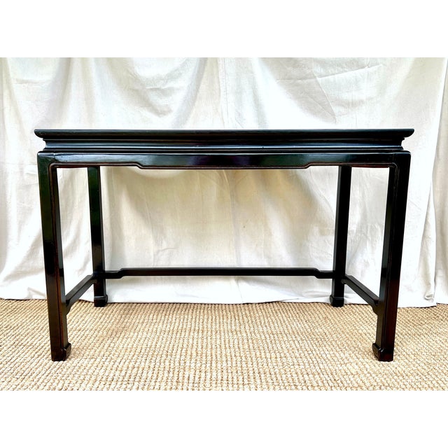 A vintage Henredon ebonized mahogany Ming style Console table or desk. The frame of solid mahogany with veneered central...