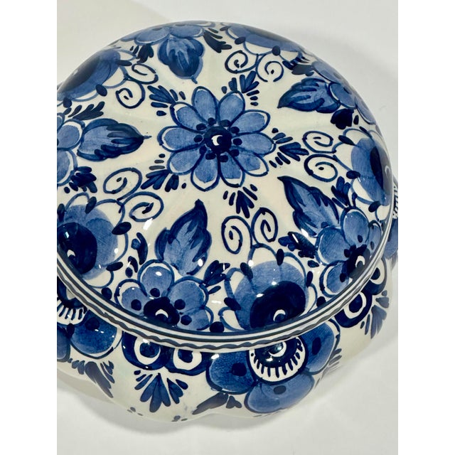 Hand-painted Dutch Delft blue and white covered trinket box featuring richly detailed floral decoration in layered cobalt...